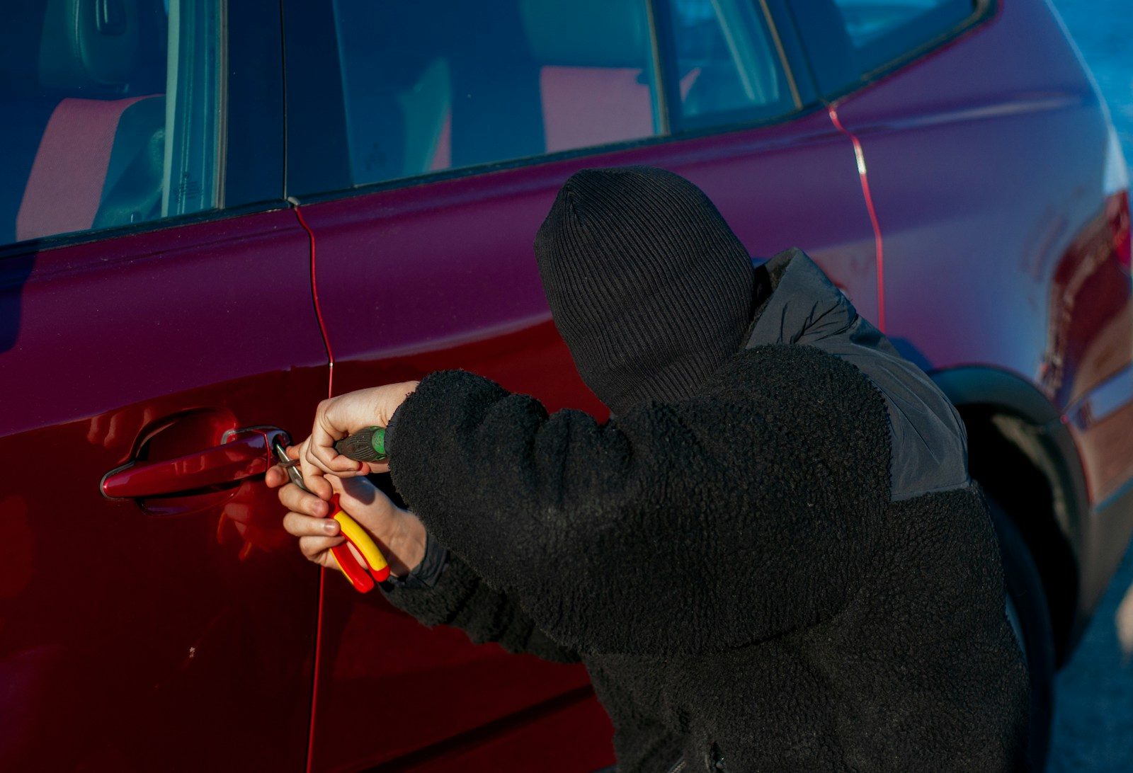 A person is trying to break into a car.