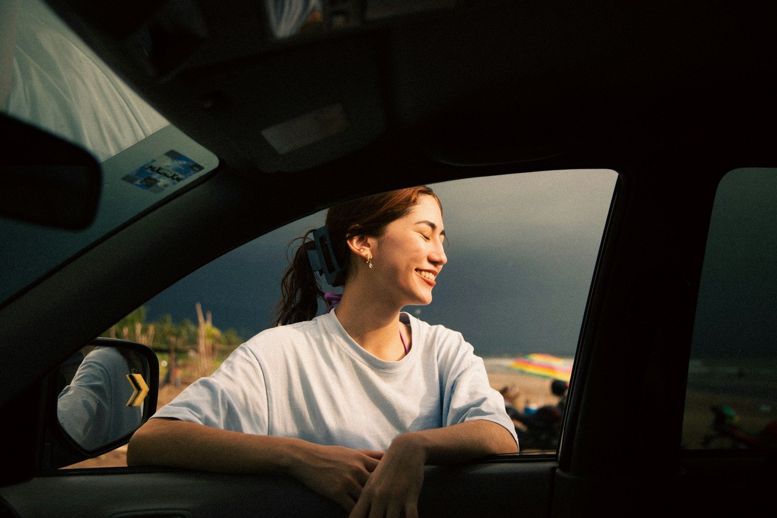 Young woman looking out of car window at sunset